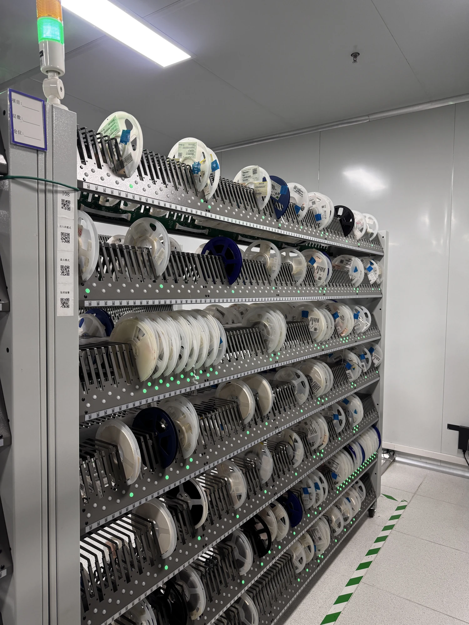 Electronic component reels organized in an illuminated storage rack